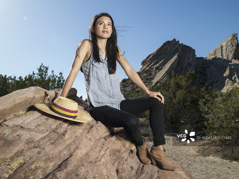 坐在沙漠岩石上的女人图片素材