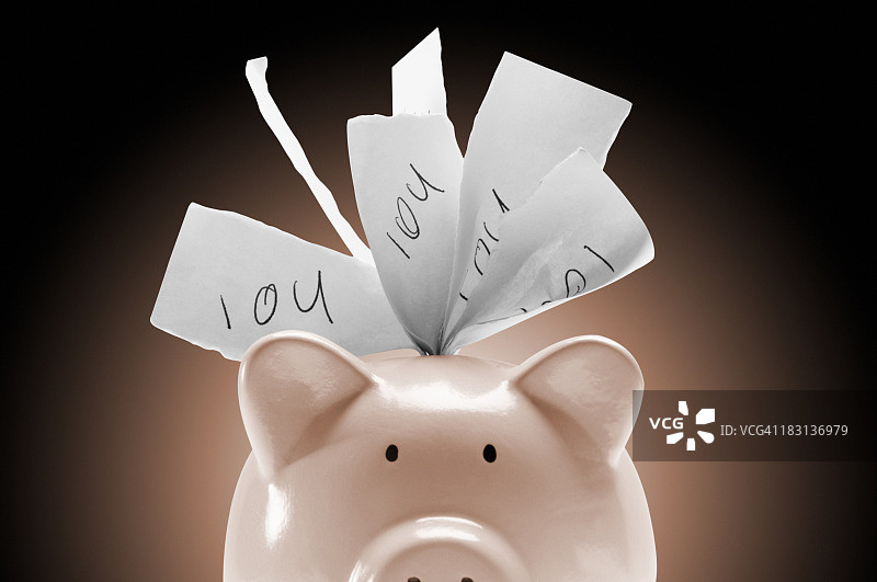 粉色背景上装满借据的储蓄罐图片素材