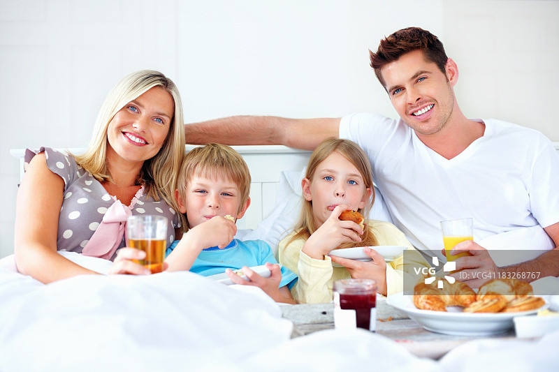 幸福一家人与孩子们在床上享用早餐图片素材