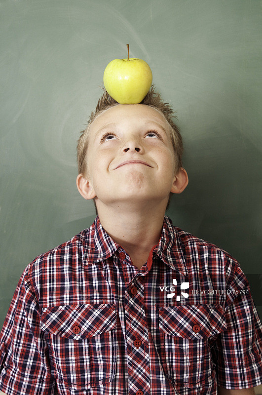 上学日：头顶苹果的男孩图片素材