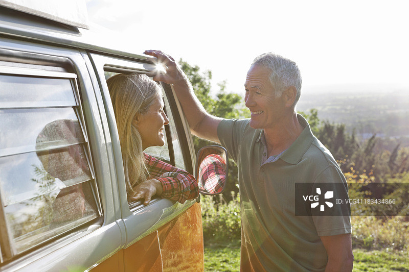 微笑的男人在露营车里和女人说话图片素材