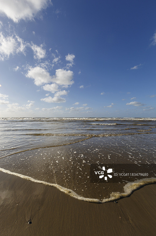 低角度拍摄：海浪拍打沙滩图片素材