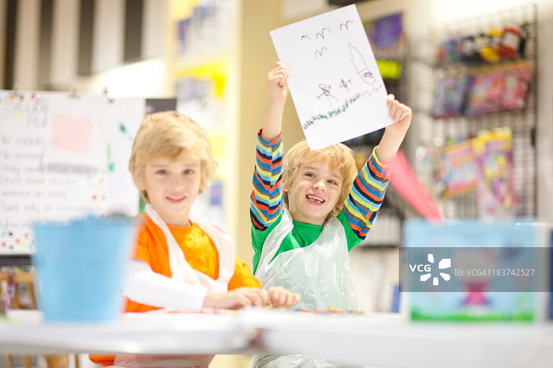 男孩举起他的画作图片素材