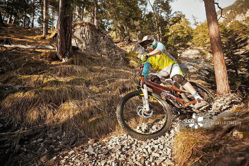男人在岩石上骑山地自行车图片素材