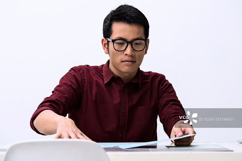 年轻男设计师在办公桌上看样品图片素材
