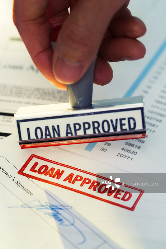 在银行文件上手动盖章“贷款已批准”图片素材