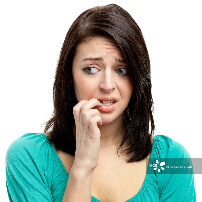 紧张的年轻女人咬指甲并看向别处图片素材