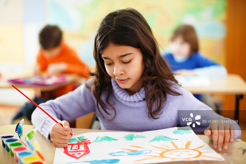女孩在美术课上用水彩画画图片素材