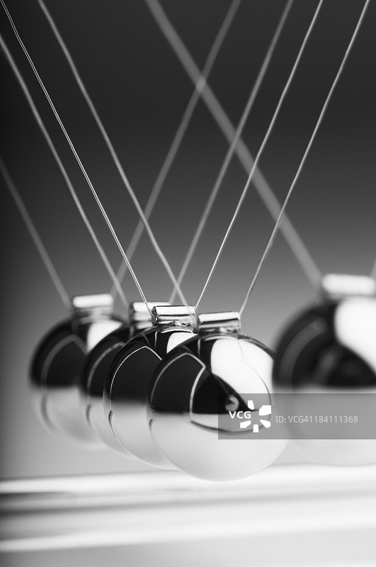 牛顿摆中银色球摆向其他球图片素材