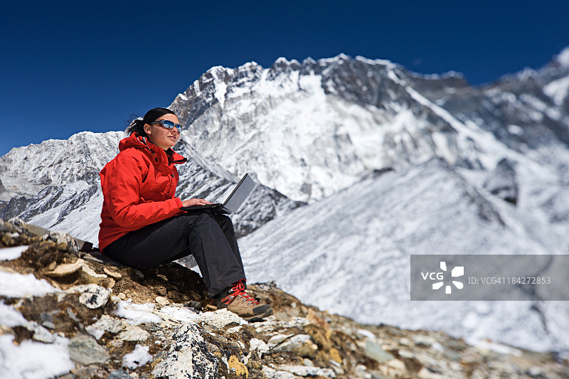 女人在尼泊尔珠穆朗玛峰国家公园使用笔记本电脑图片素材