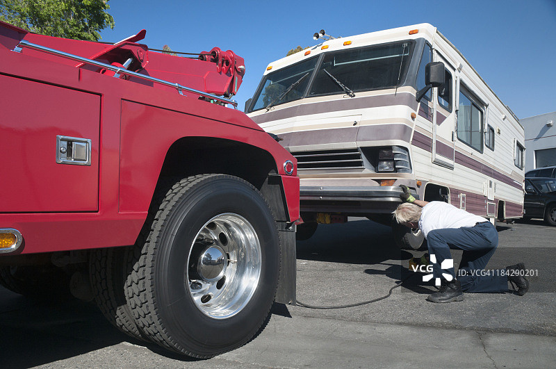 拖车司机正在修理抛锚的房车图片素材
