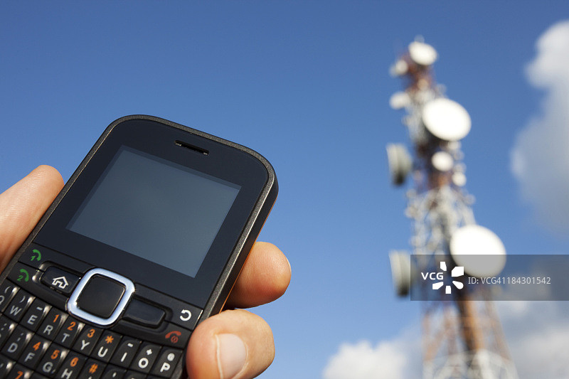 手持手机和通信塔图片素材
