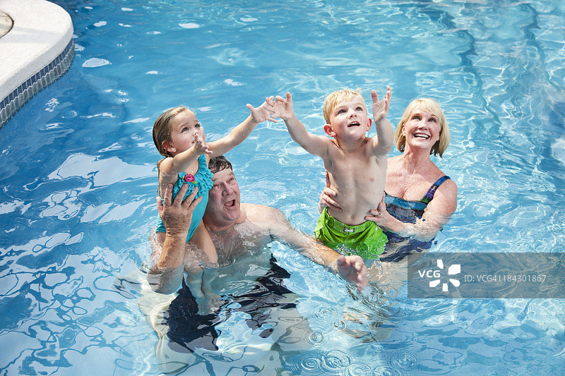 和祖父母在游泳池里的孩子们图片素材