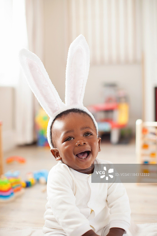 戴着兔子头带微笑的非洲婴儿，南非开普敦图片素材