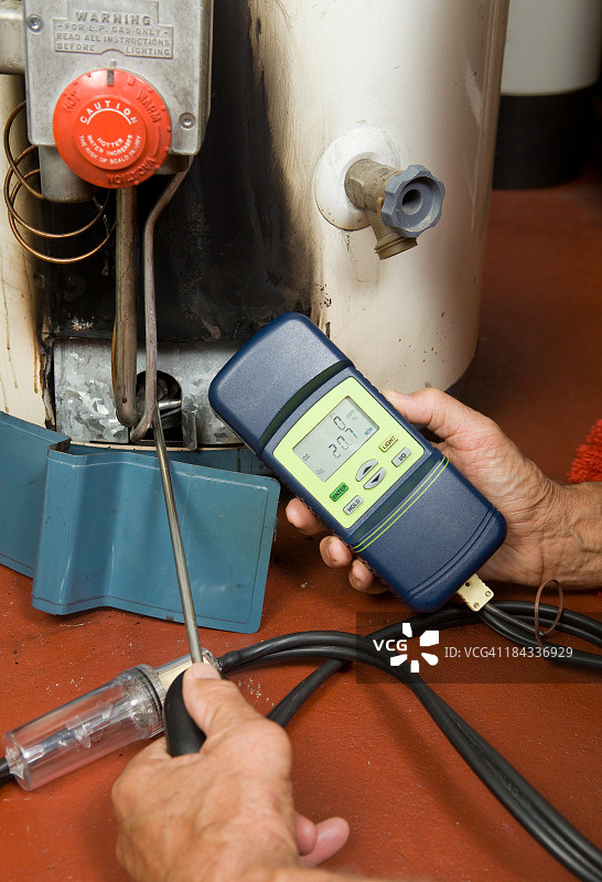 维修人员检查燃气热水器燃烧器的一氧化碳含量图片素材
