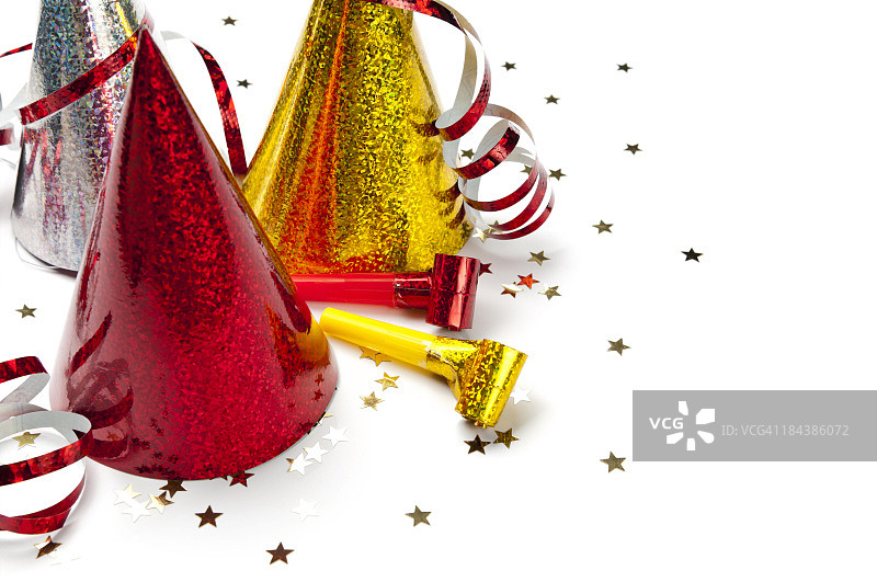 派对帽、口哨、彩带、五彩纸屑的特写，白色背景图片素材