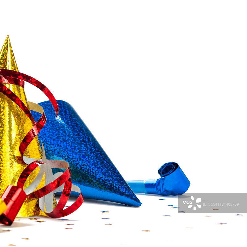 白色背景上派对帽、口哨、彩纸和彩带特写图片素材