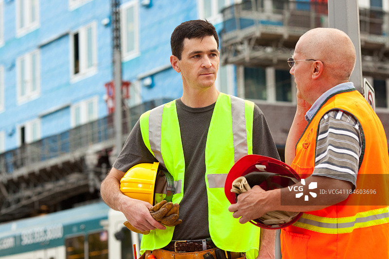 两位男建筑工人拿着安全帽图片素材