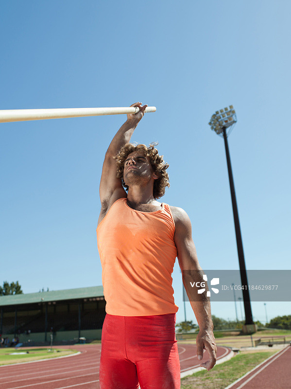 在竞技场上撑杆跳高的运动员图片素材