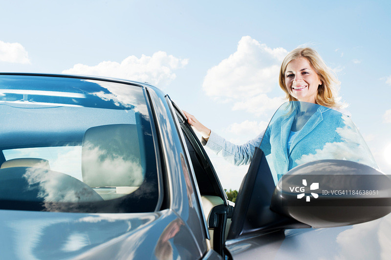 年轻有魅力的女子正在打开她的车门图片素材