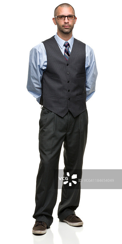 戴眼镜、穿休闲鞋站立的商人图片素材