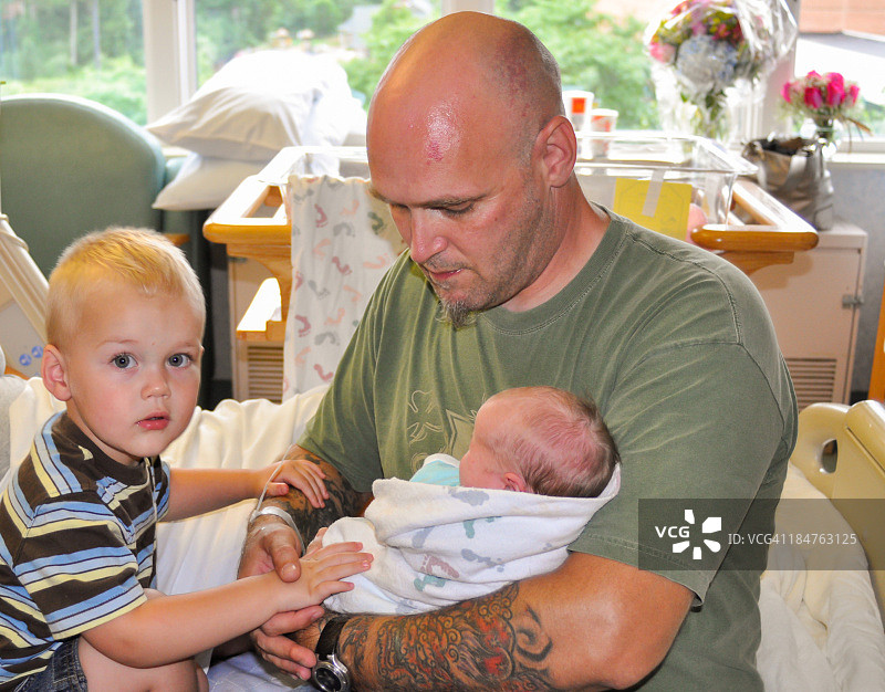 父亲和蹒跚学步的儿子及新生女儿图片素材