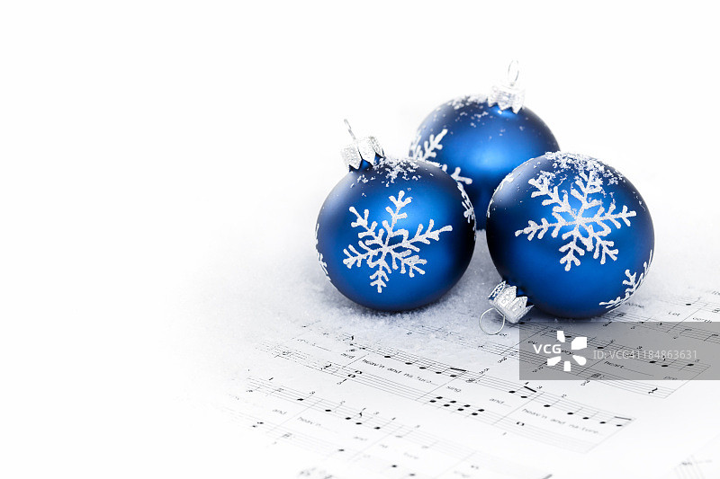 圣诞颂歌乐谱上的蓝色小饰品图片素材