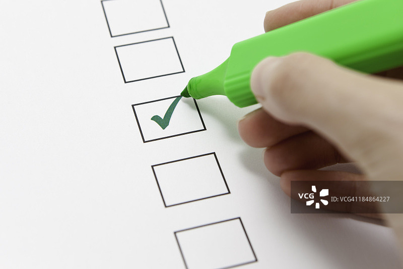 用绿色荧光笔在表格上打勾的人图片素材