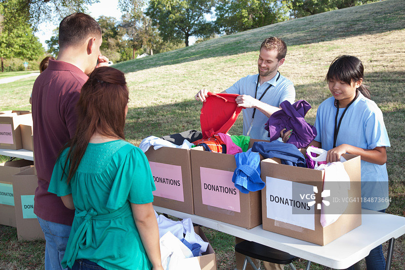 志愿者在捐赠中心接收捐赠者捐赠的衣物图片素材