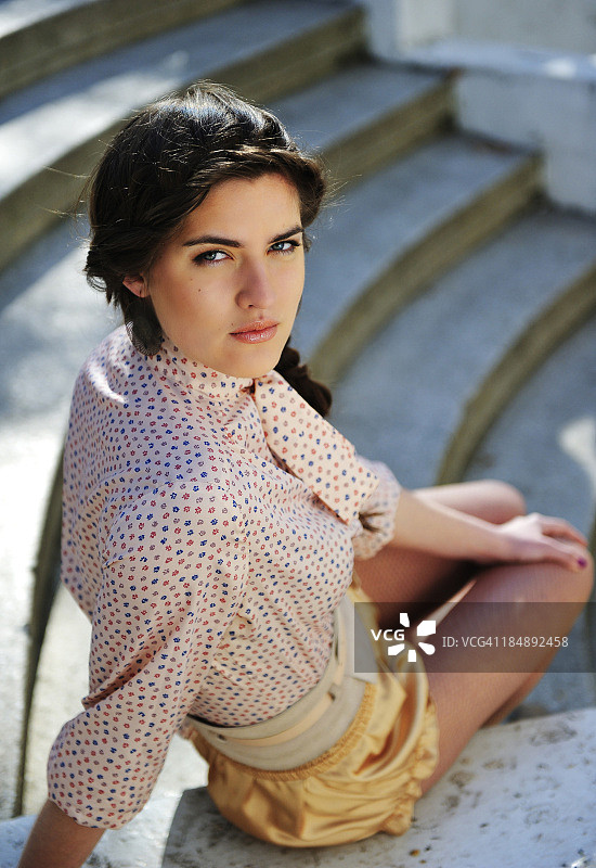 年轻女子坐在水泥台阶上的肖像图片素材