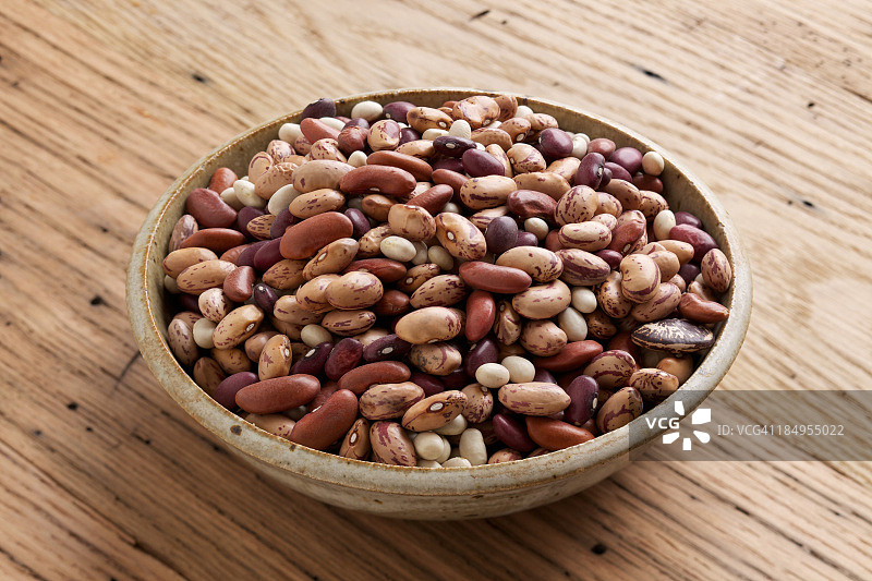 木桌上的混合干豆碗图片素材