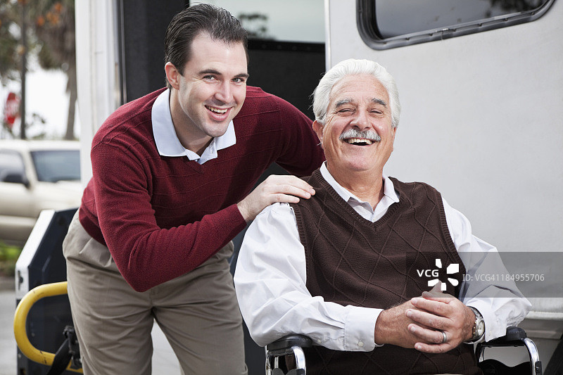 年长的男人在带有轮椅升降机的迷你巴士旁图片素材