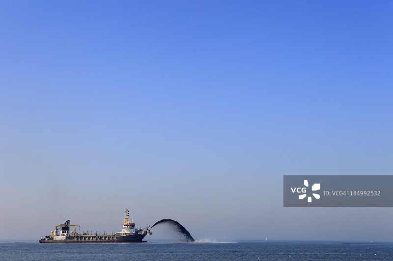 挖泥船向海岸线输送沙子图片素材