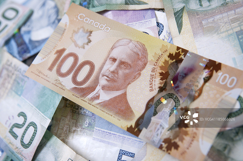 一堆加拿大钞票，最上面是一百元图片素材