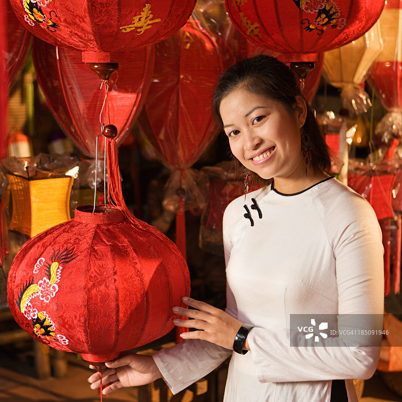 年轻女人在越南会安市展示丝绸灯笼图片素材