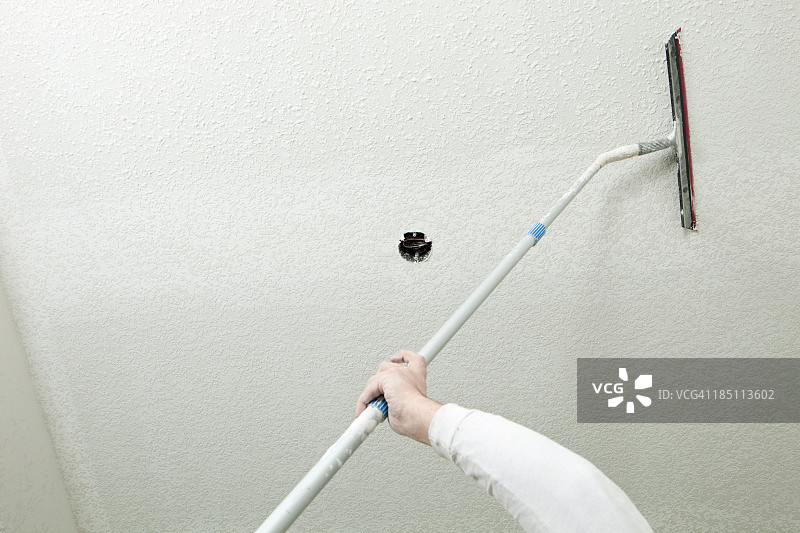 工人在天花板上涂抹腻子图片素材