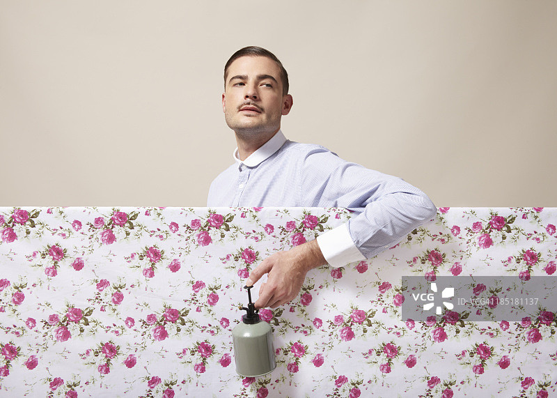 一位衣着考究的男士在布料上喷洒鲜花图片素材