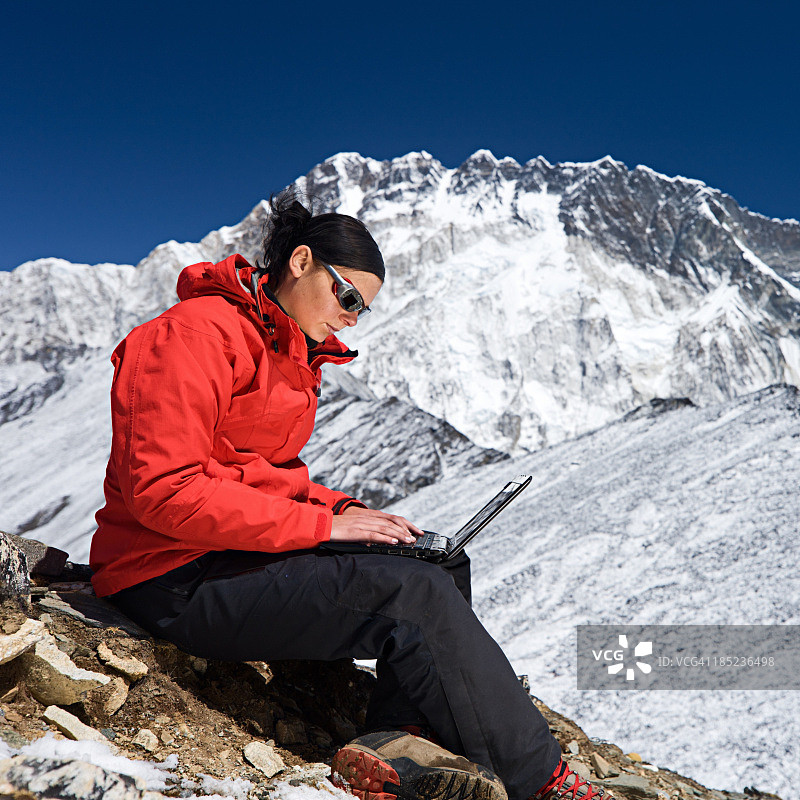 女人在尼泊尔珠穆朗玛峰国家公园使用笔记本电脑图片素材