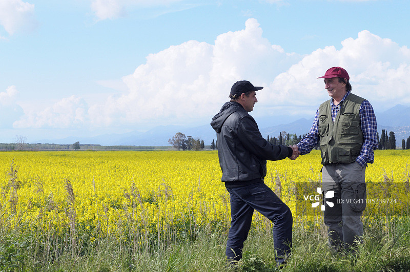 两位农民在乡间握手图片素材
