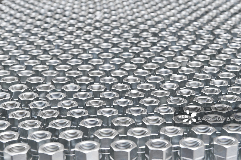 许多银色螺母整齐排列。图片素材