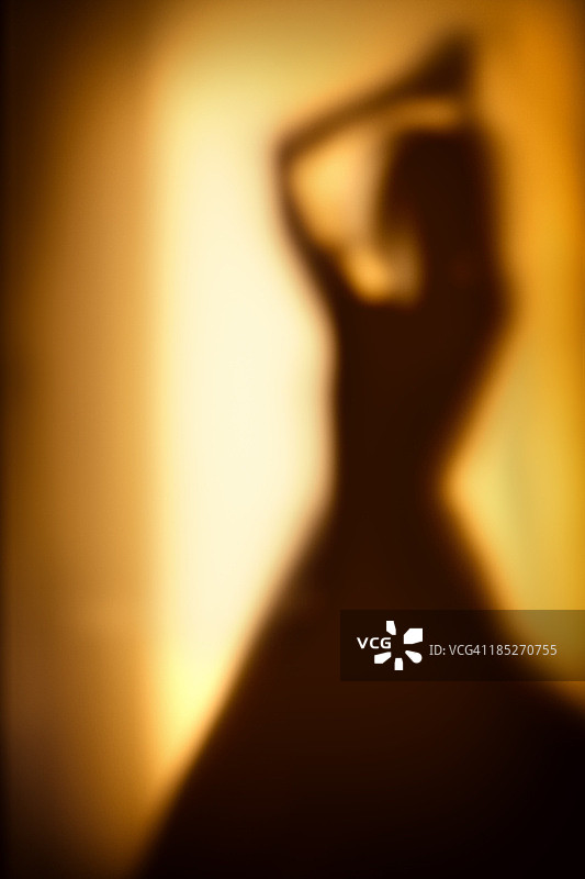 在阴影中隔着玻璃跳舞的女人轮廓图片素材
