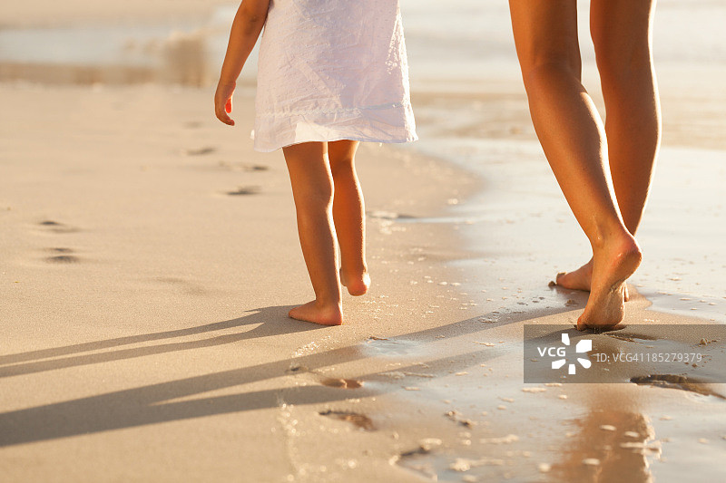 母亲和女儿在海滩上散步图片素材