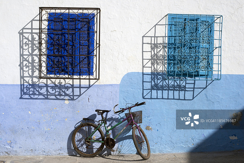 摩洛哥艾西拉海滨小镇的抽象窗户与自行车图片素材