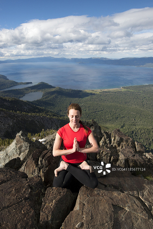 在一个美丽的下午，女人在塔拉克山顶上做瑜伽，俯瞰太浩湖，靠近南太浩湖，加利福尼亚州图片素材