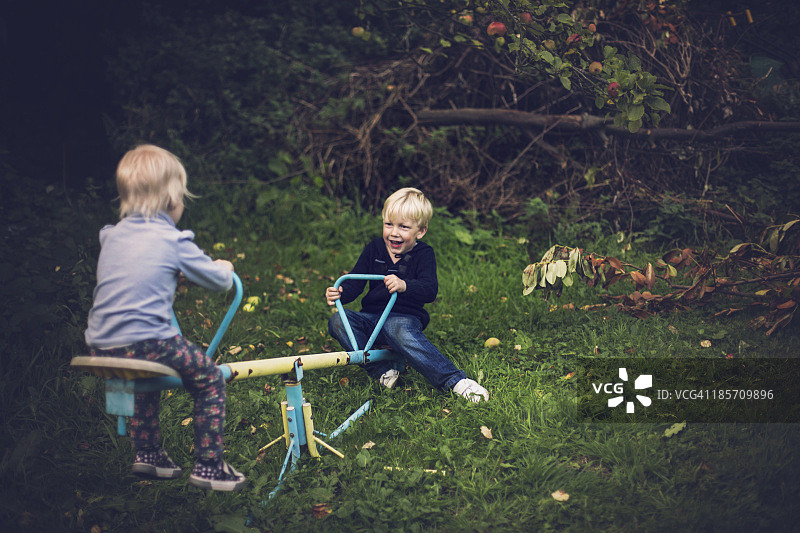 快乐的孩子们玩跷跷板图片素材