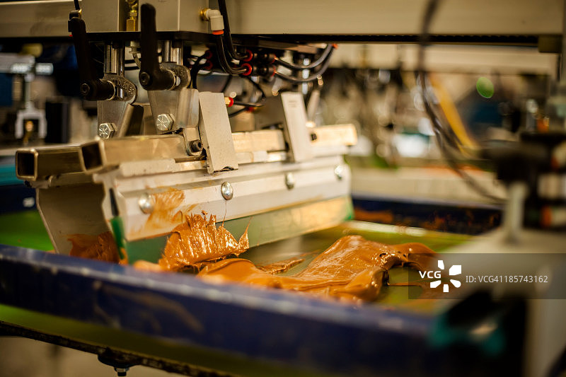 丝网印刷机在框架上涂抹油墨图片素材