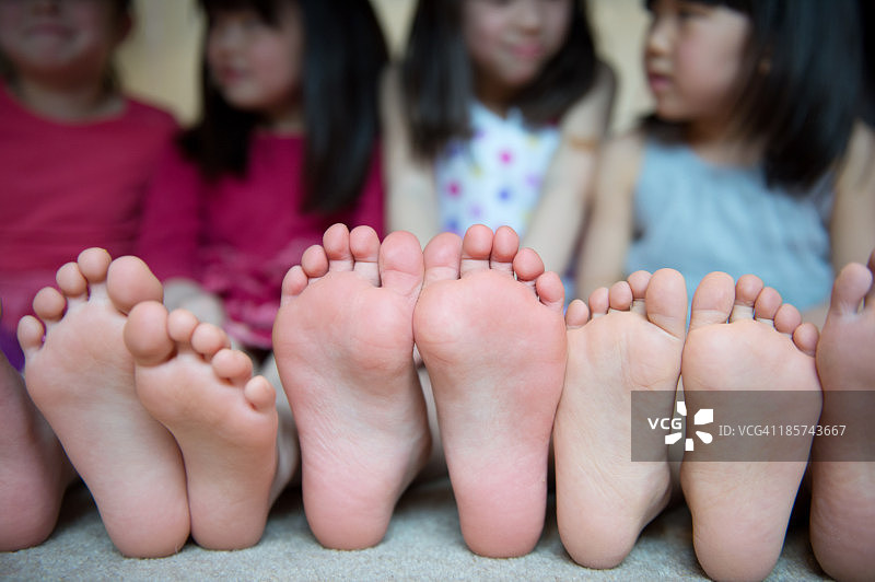 女孩们赤脚并排坐在一起图片素材