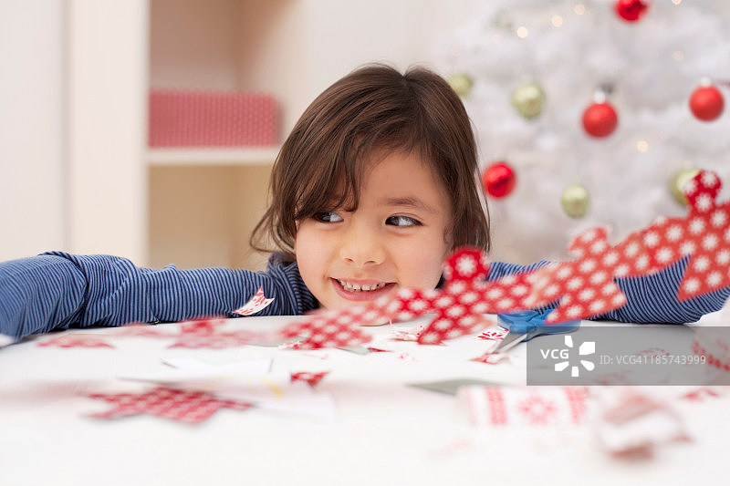 女孩拿着圣诞装饰品，面带微笑图片素材