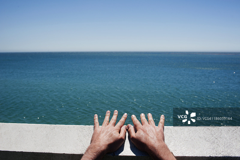 男人扶着海边栏杆图片素材