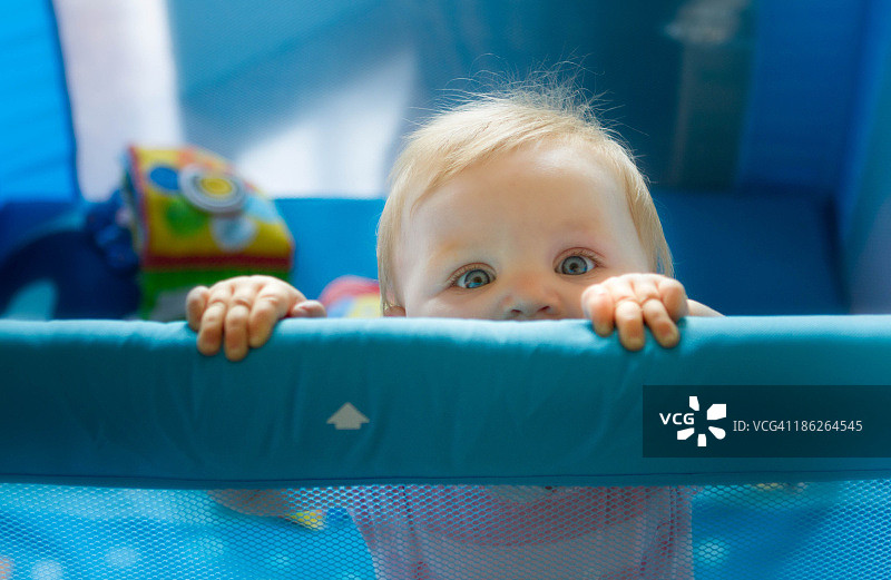 女婴在婴儿围栏中图片素材